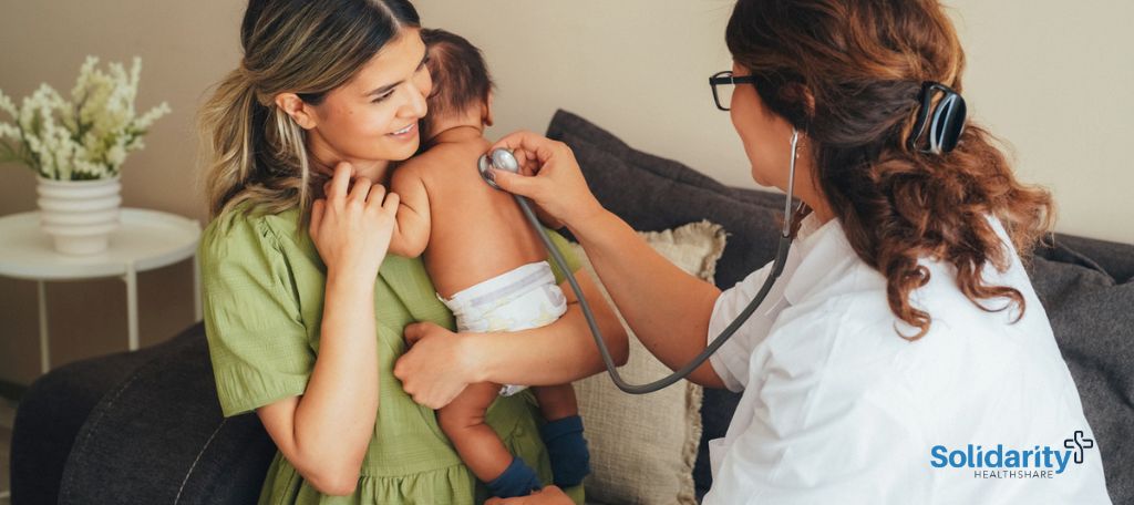 Midwife performing a check-up on a baby, who is being held by its mother.